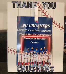 9U Corinth Crushers youth baseball team thanking European Service Center for sponsorship, displayed on a thank-you board.